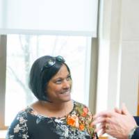 President Haas speaking with a woman at the event.